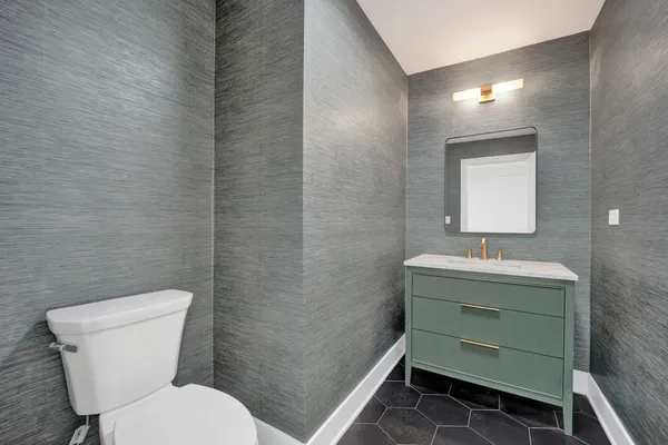 a bathroom with a toilet sink and mirror