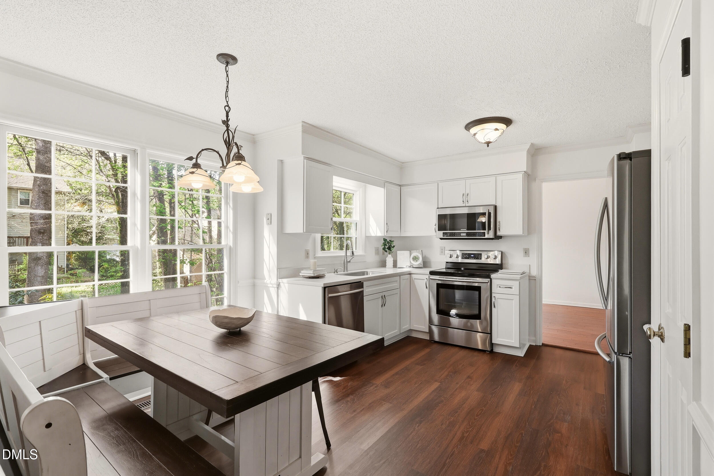 107 Canyon Run Cary, NC 27513 - Photo 14 of 43 a kitchen with a stove a sink dishwasher a refrigerator and a dining table with wooden floor