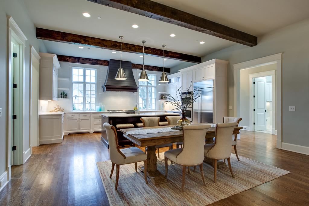 1205 Echo Lane Franklin, TN 37069 - Photo 14 of 29 a kitchen with stainless steel appliances kitchen island granite countertop a table chairs in it and wooden floors
