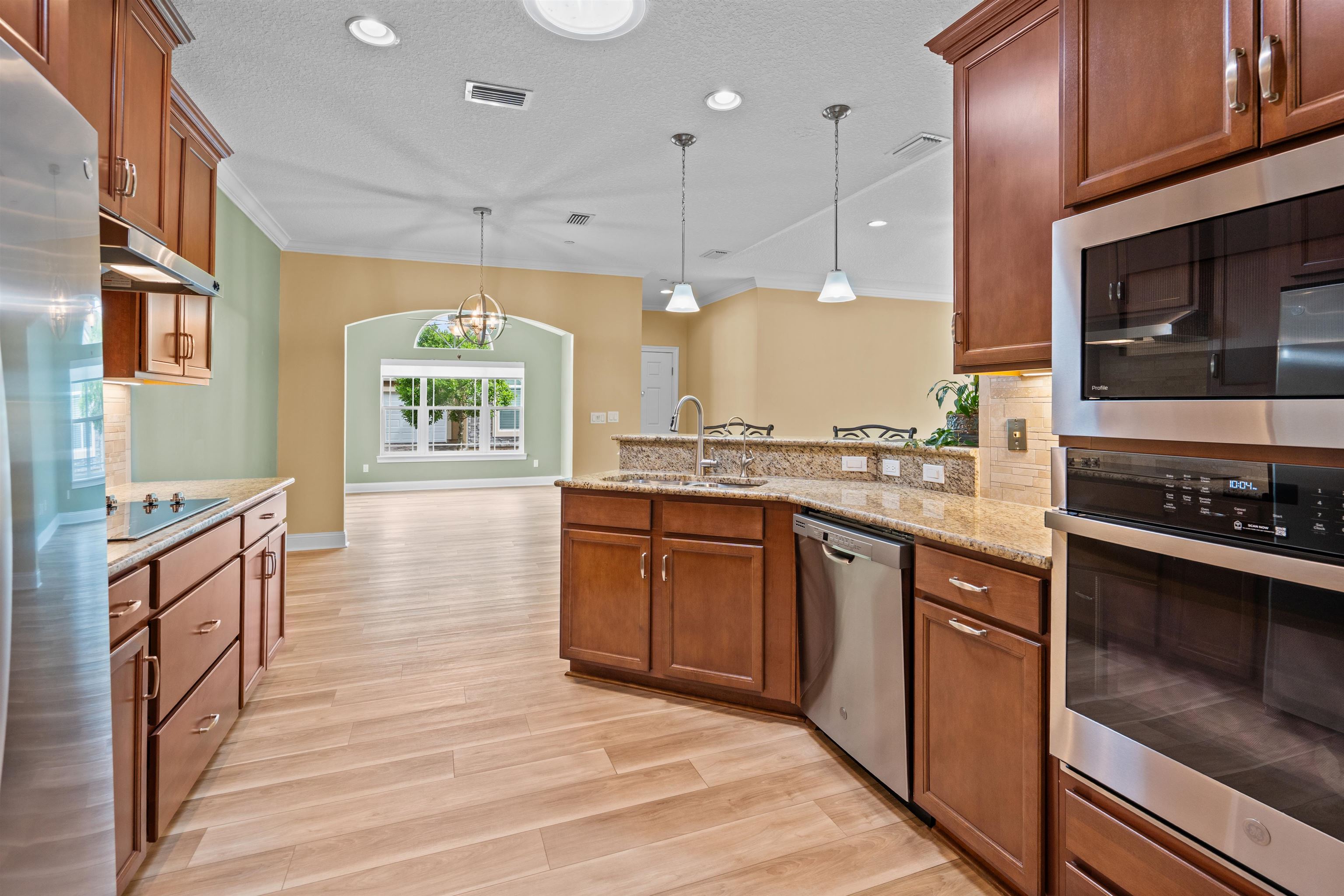 148 Timoga Trail St. Augustine, FL 32084 - Photo 16 of 46 a large kitchen with stainless steel appliances granite countertop a stove a sink dishwasher and a microwave oven with large wooden cabinets