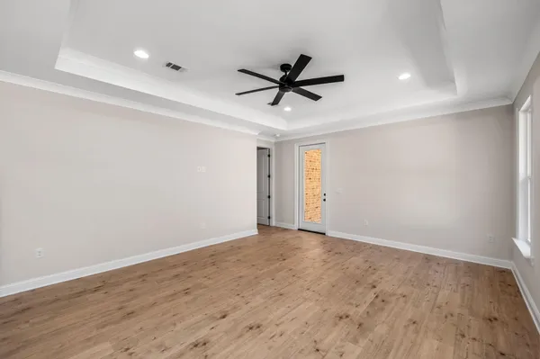 a view of a big room with wooden floor and windows in a room