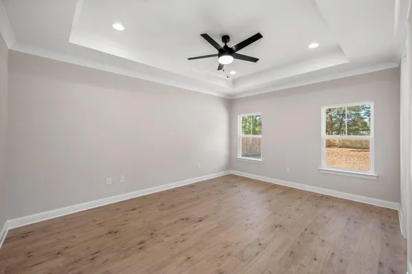 an empty room with windows and fan