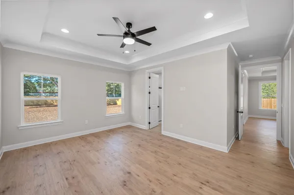 a view of an empty room with a window and wooden floor