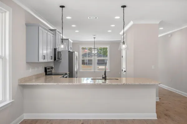 a large kitchen with stainless steel appliances granite countertop a sink a refrigerator and a granite counter tops