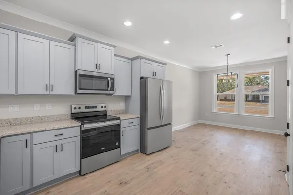 a kitchen with stainless steel appliances granite countertop a refrigerator a stove a sink and a microwave