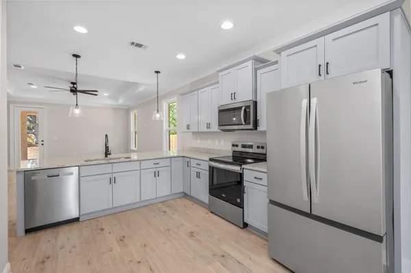 a large kitchen with cabinets stainless steel appliances and a counter space
