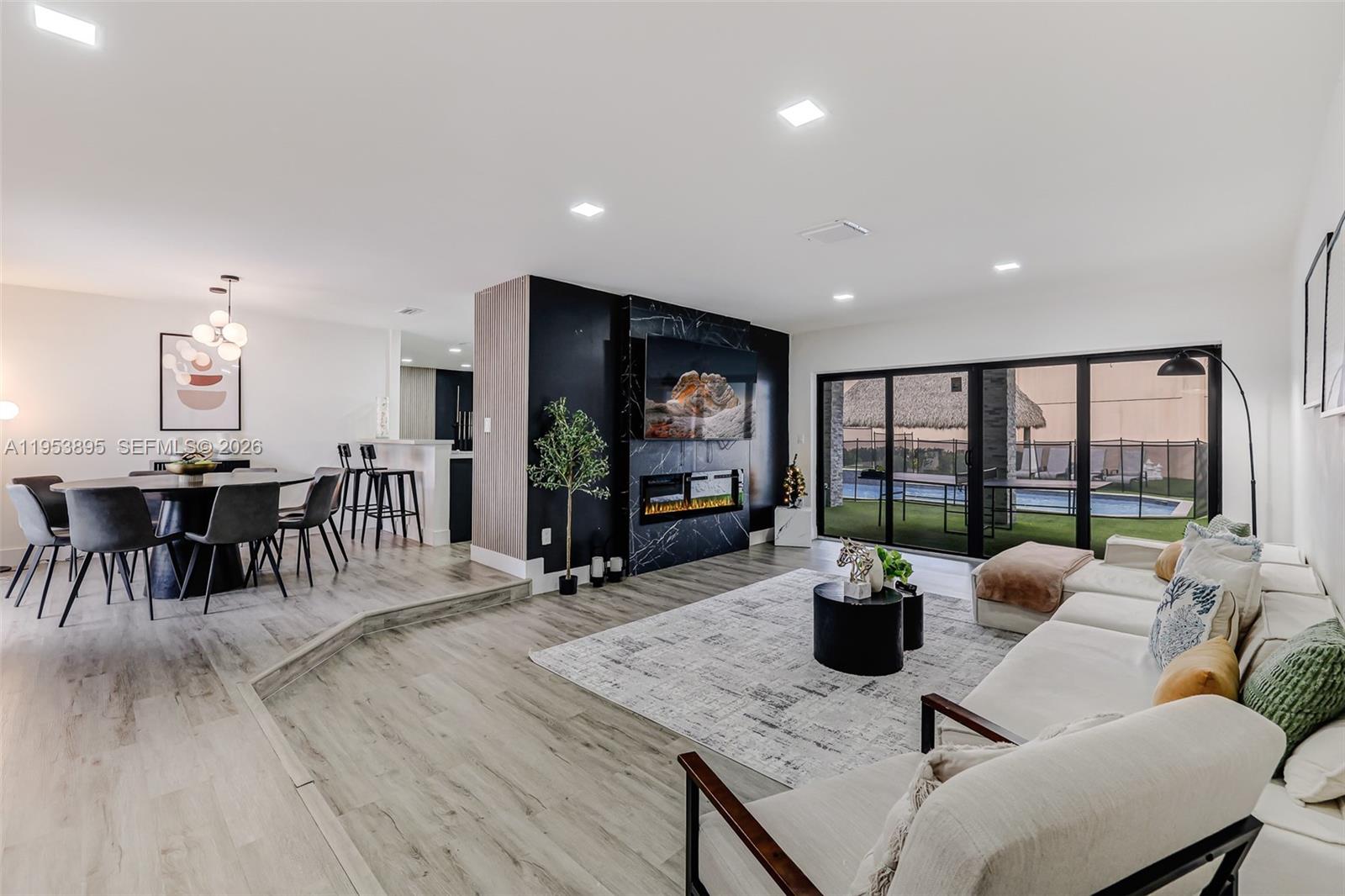 10870 Southwest 106th Avenue Miami, FL 33176 - Photo 12 of 48 a living room with furniture a flat screen tv and a floor to ceiling window