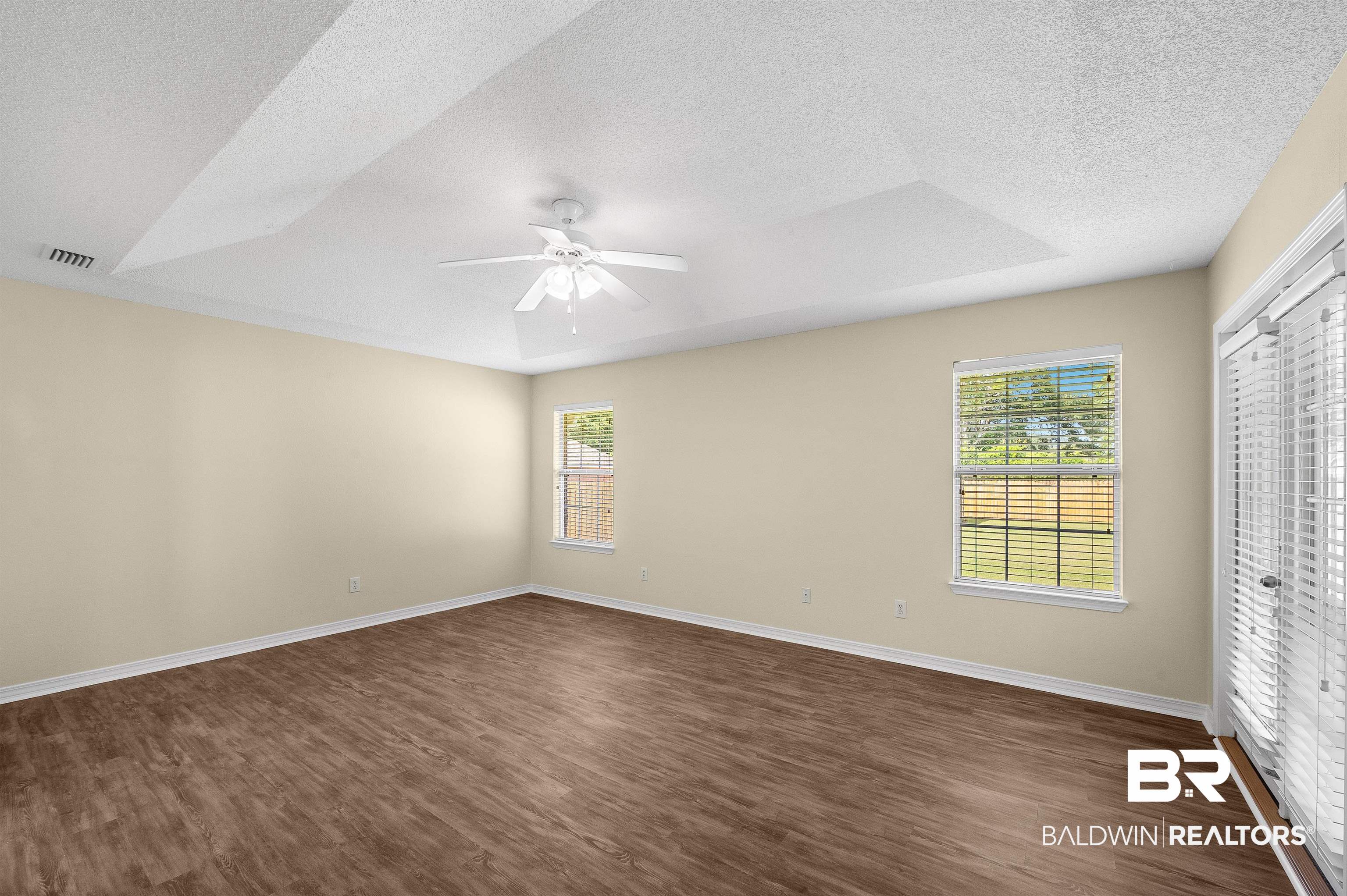 12443 Venice Boulevard Foley, AL 36535 - Photo 39 of 59 Spare room with a tray ceiling, dark wood-type flooring, a textured ceiling, and ceiling fan