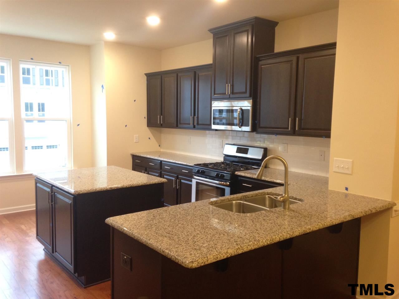 714 Edgewater Ridge Court Apex, NC 27523 - Photo 3 of 8 Kitchen has peninsula one-level counter with overhang for stools PLUS large center ISLAND!