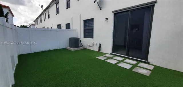a backyard of a house with lots of green space and plants