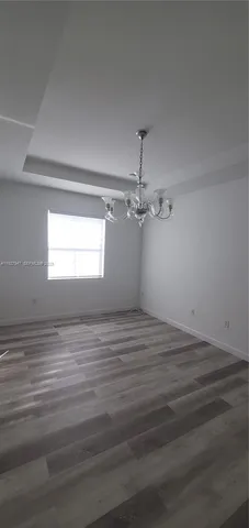 a view of empty room with window and ceiling fan