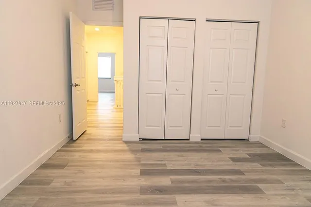 a view of a small space with wooden floor and a window