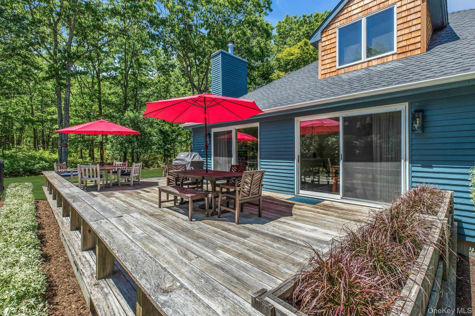 16 Hildreth Road Hampton Bays, NY 11946 - Photo 27 of 29 a view of a patio with a table and chairs under an umbrella