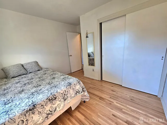 a bedroom with a bed and wooden floor