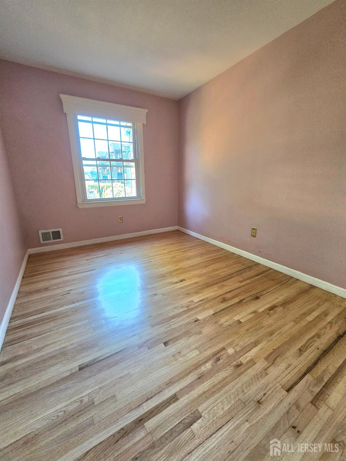 124 Howell Avenue Fords, NJ 08863 - Photo 13 of 23 an empty room with wooden floor and windows