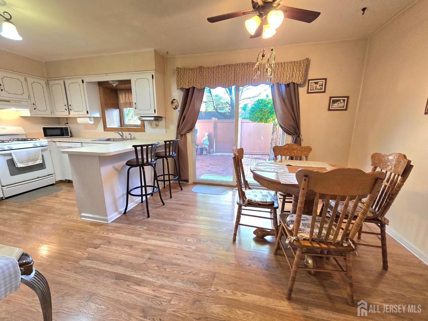124 Howell Avenue Fords, NJ 08863 - Photo 4 of 23 a dining room with wooden floor a chandelier a glass table and chairs