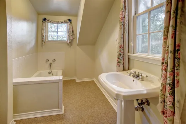 a bathroom with a sink a window and a bathtub