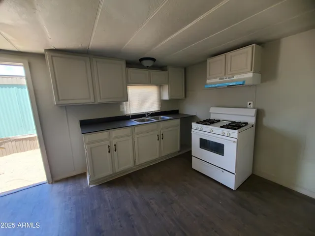 a kitchen with granite countertop white cabinets and white appliances
