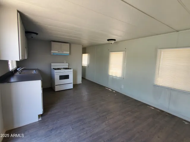 a kitchen with granite countertop a stove a sink and a refrigerator