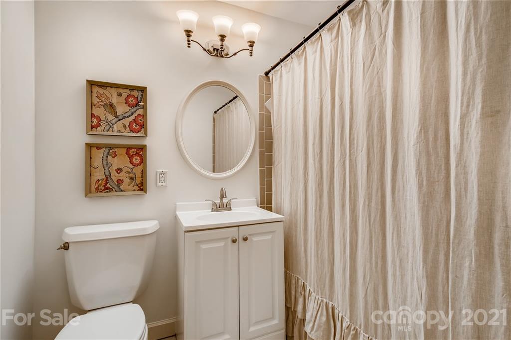 3929 Glenfall Avenue Charlotte, NC 28210 - Photo 15 of 30 a bathroom with a toilet a sink and a mirror