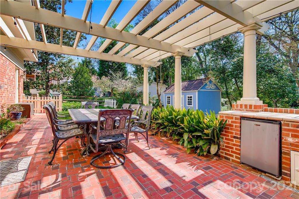 3929 Glenfall Avenue Charlotte, NC 28210 - Photo 28 of 30 a view of a patio with table and chairs potted plants with wooden floor and floor to ceiling window