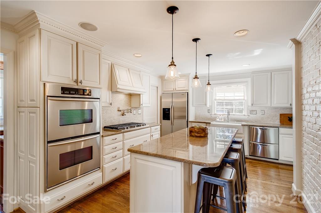 3929 Glenfall Avenue Charlotte, NC 28210 - Photo 7 of 30 a kitchen with stainless steel appliances a stove a sink a microwave a dining table and chairs