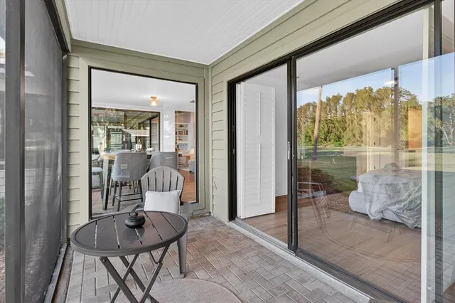 a kitchen with stainless steel appliances granite countertop a refrigerator a sink dishwasher a dining table and chairs with wooden floor