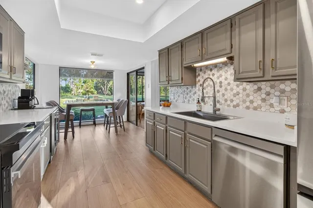 a kitchen with stainless steel appliances sink refrigerator and cabinets