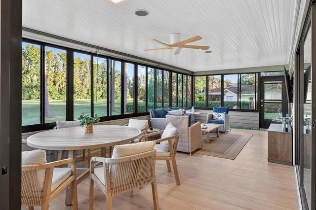 a dining room with furniture water view and a floor to ceiling window