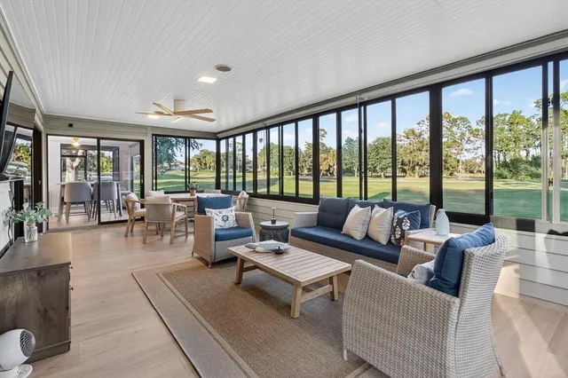 a living room with furniture flat screen tv and a large window