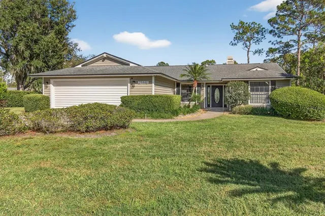 an aerial view of residential houses with outdoor space and trees