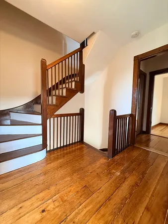 a view of staircase with railing and a rug