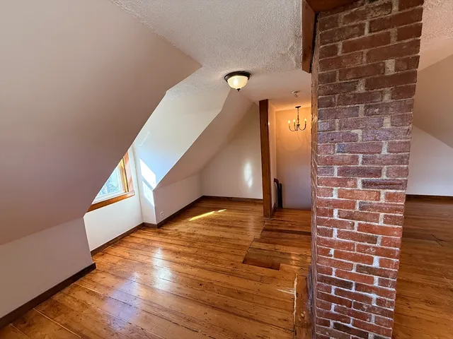 a view of a room has wooden floor and stairs