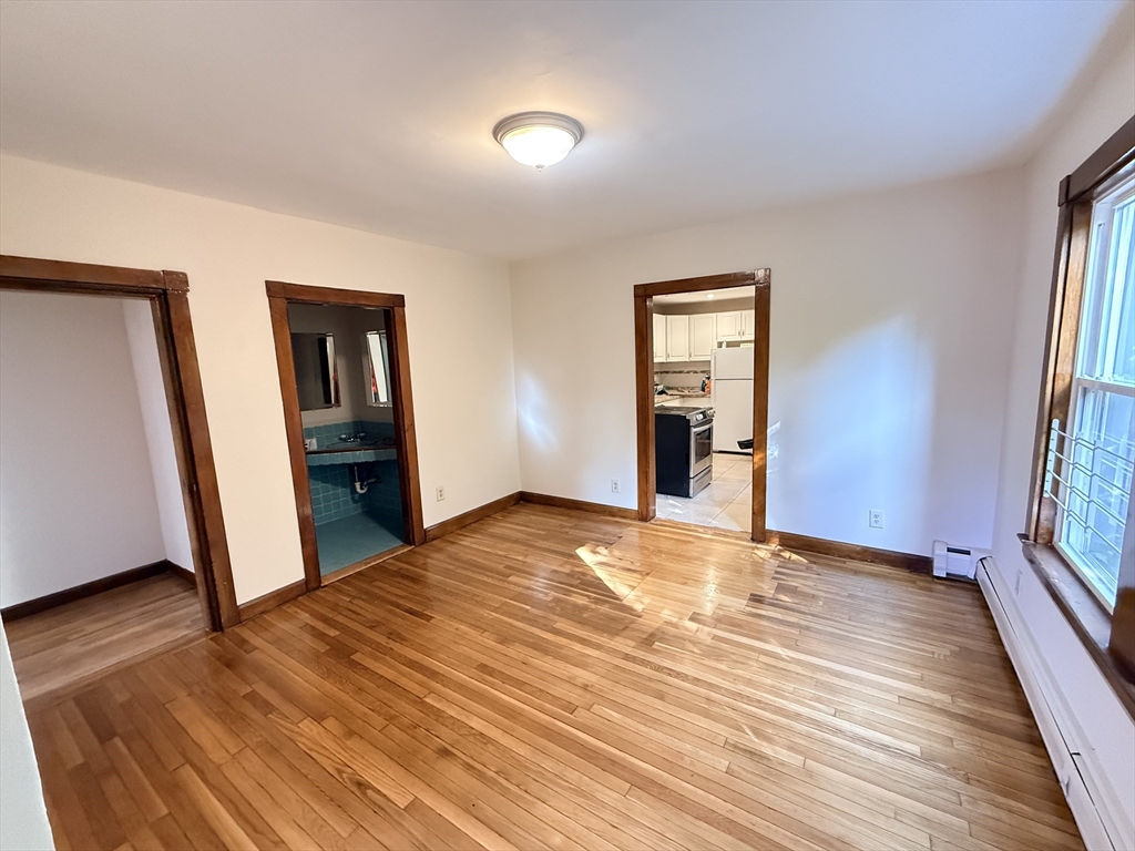 5 Oakland Street, Unit 1 Boston, MA 02119 - Photo 3 of 25 a view of empty room with wooden floor and fan