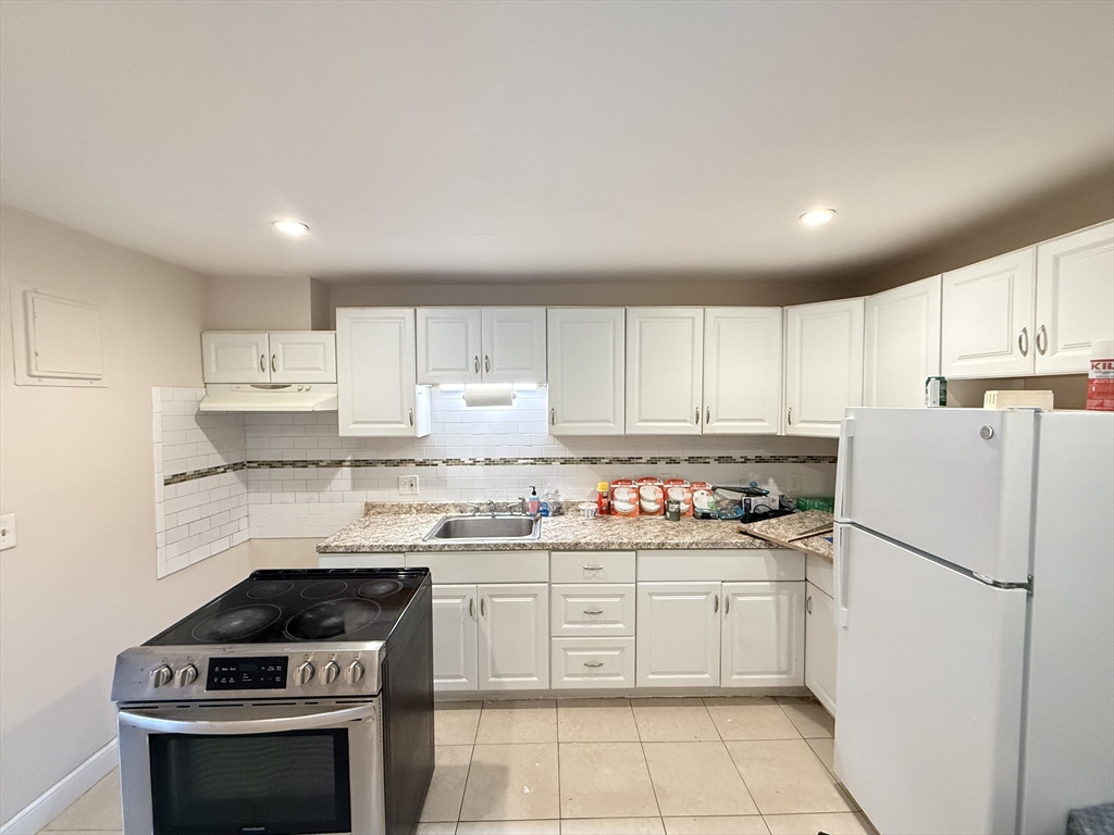 5 Oakland Street, Unit 1 Boston, MA 02119 - Photo 5 of 25 a kitchen with a stove sink and refrigerator