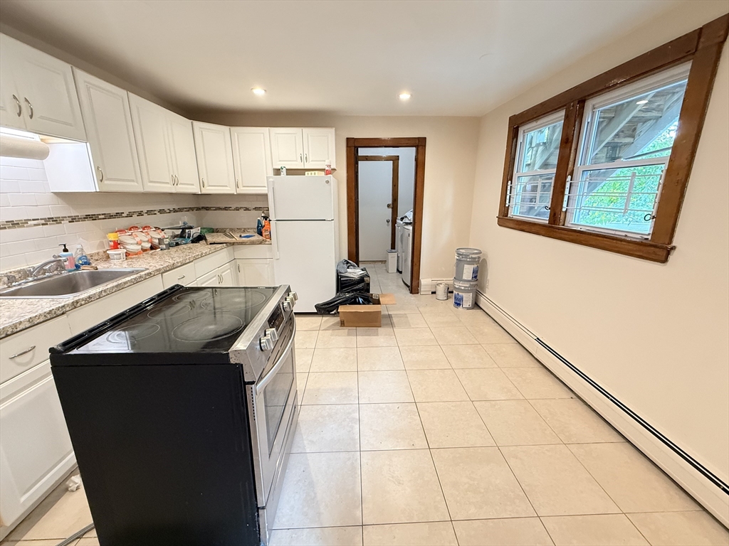 5 Oakland Street, Unit 1 Boston, MA 02119 - Photo 6 of 25 a kitchen with a sink stove and cabinets