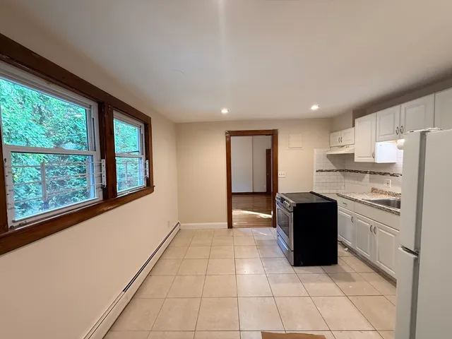 a kitchen with granite countertop a refrigerator and a stove top oven