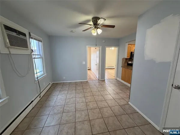 a view of empty room with window and chandelier fan