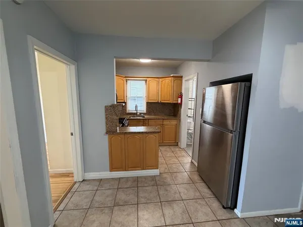 a kitchen with a refrigerator a washer dryer and cabinets