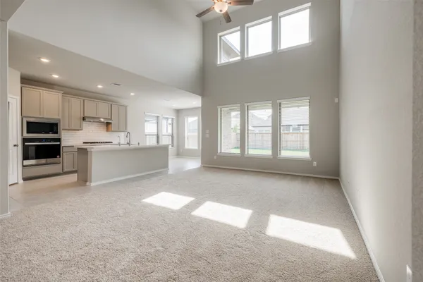 a view of a kitchen with refrigerator and windows
