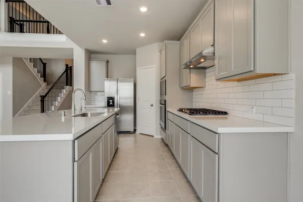 a kitchen with granite countertop a sink and refrigerator