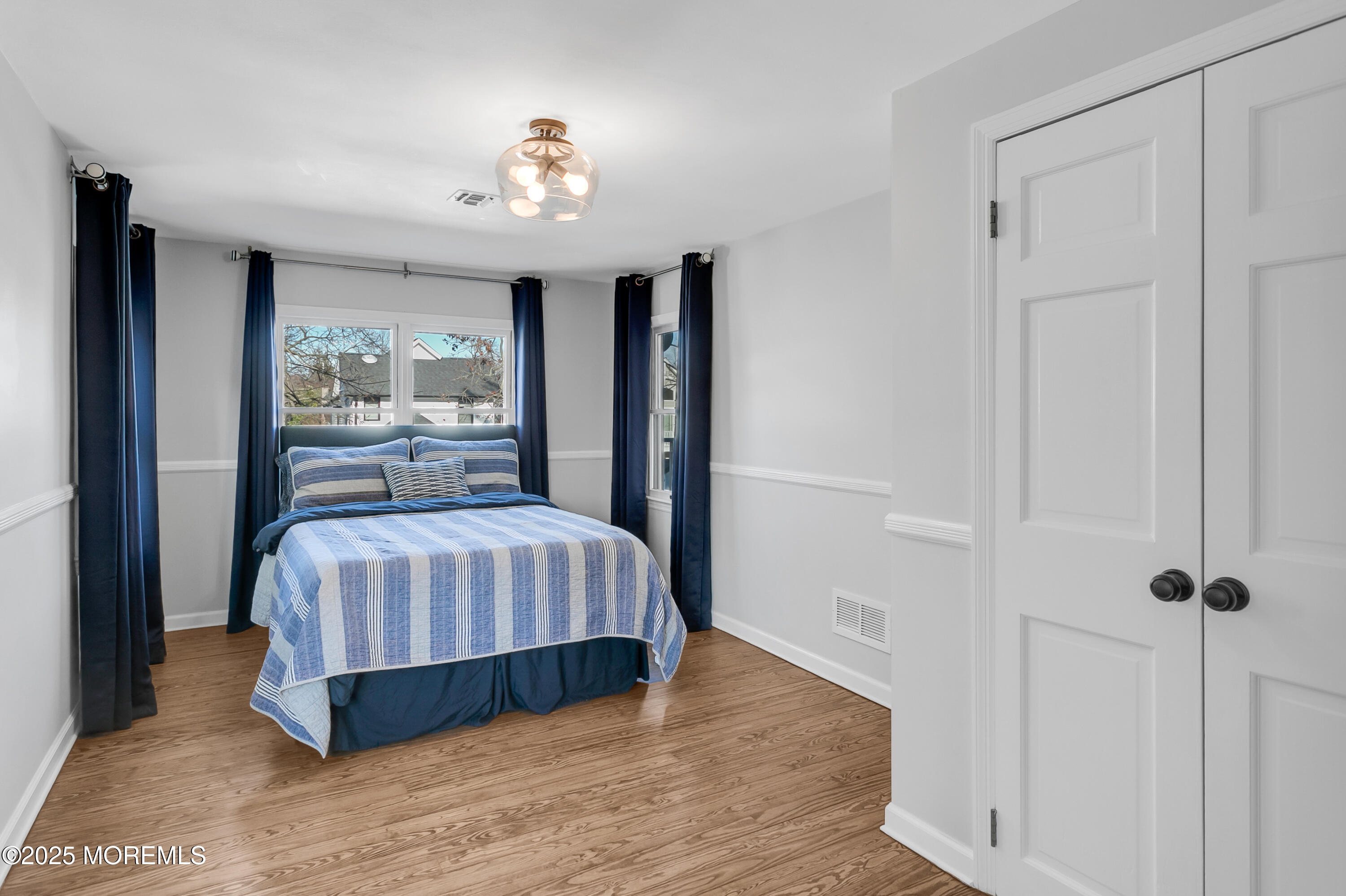 7 Allen Street Rumson, NJ 07760 - Photo 26 of 45 a bedroom with a large bed and a chandelier