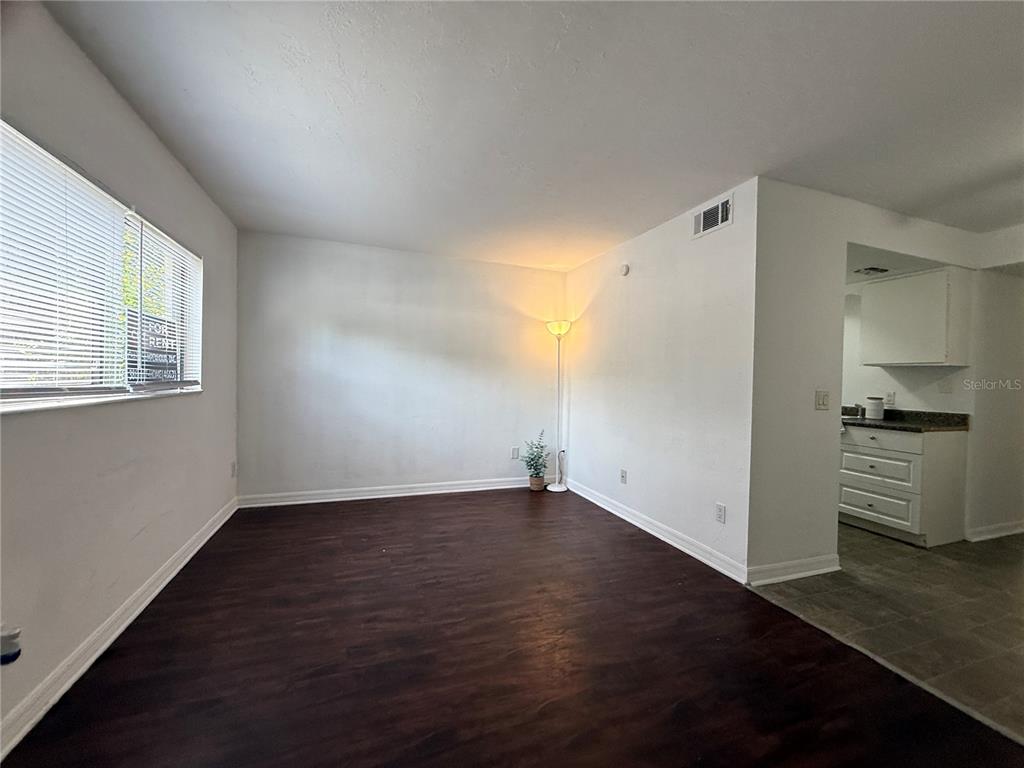 510 Southwest 69th Street, Unit A Gainesville, FL 32607 - Photo 2 of 9 an empty room with wooden floor cabinet and windows