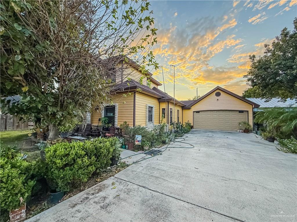 View of front of home with concrete driveway and a garage