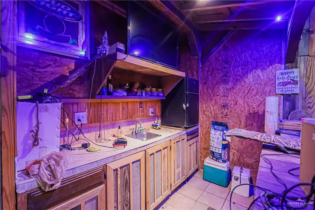 4701 Russell Circle Mission, TX 78574 - Photo 31 of 41 Bar area featuring open shelves, tile counters, and light tile patterned floors