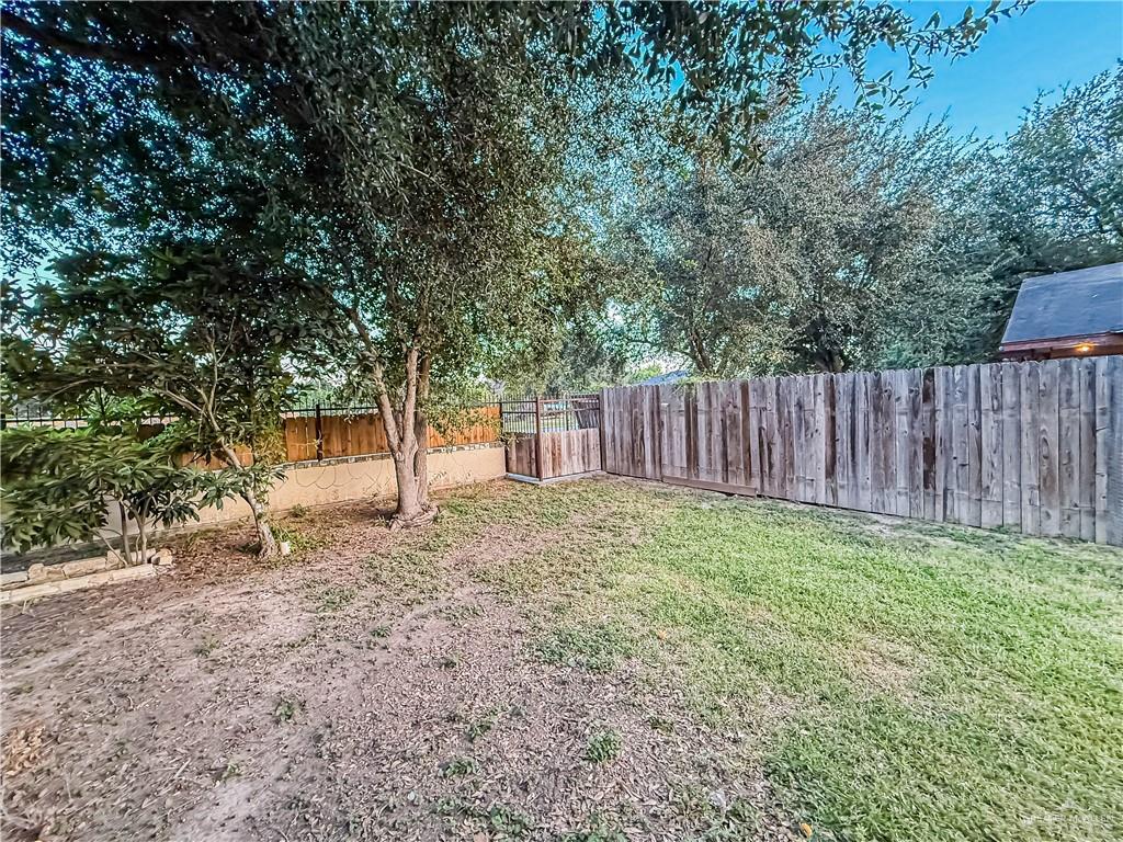 4701 Russell Circle Mission, TX 78574 - Photo 8 of 41 a view of a backyard with large trees and wooden fence