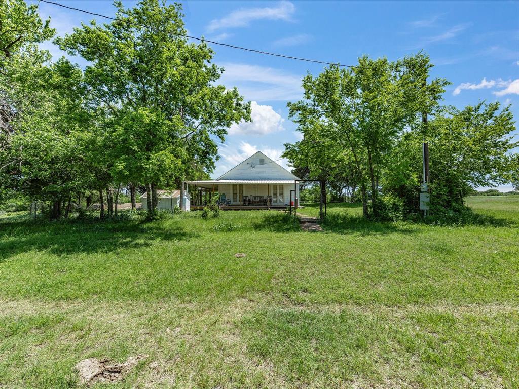 5444 Well Service Road Bowie, TX 76230 - Photo 16 of 38 a front view of a house with garden