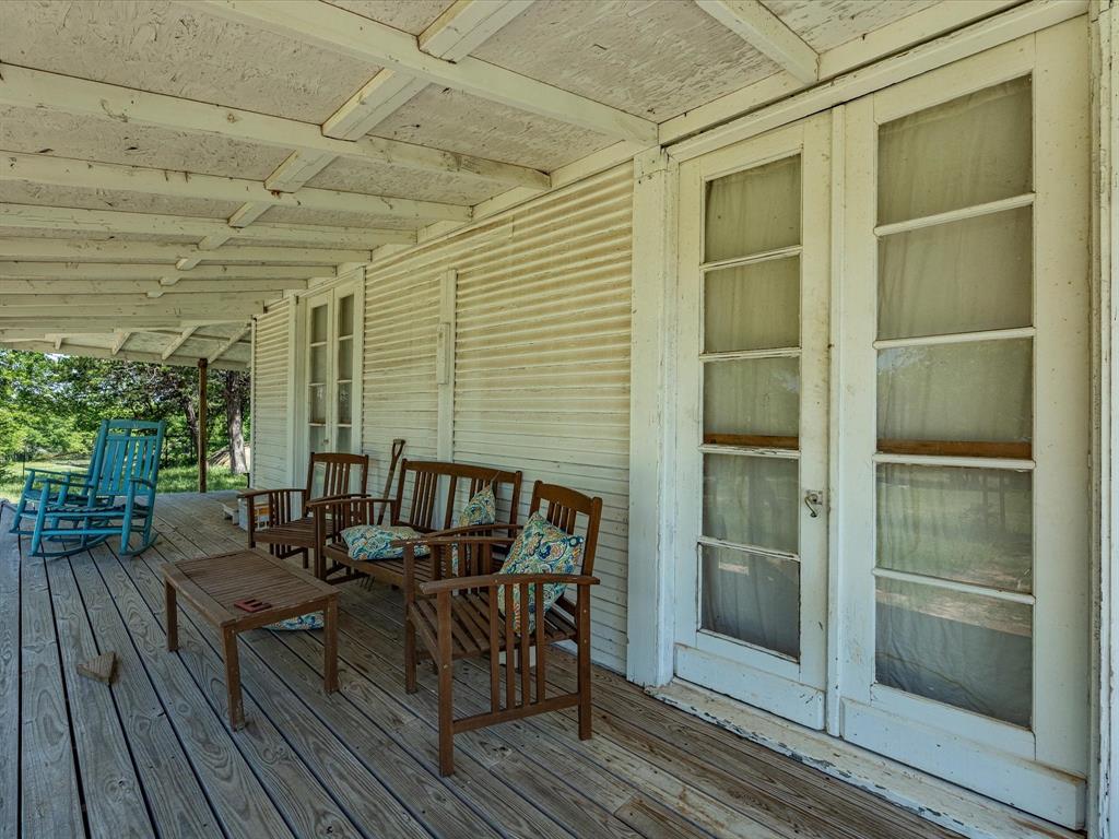 5444 Well Service Road Bowie, TX 76230 - Photo 17 of 38 a view of balcony with chairs and wooden floor