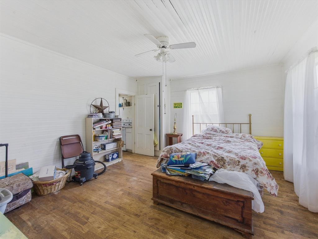 5444 Well Service Road Bowie, TX 76230 - Photo 18 of 38 a bedroom with a bed and wooden floor