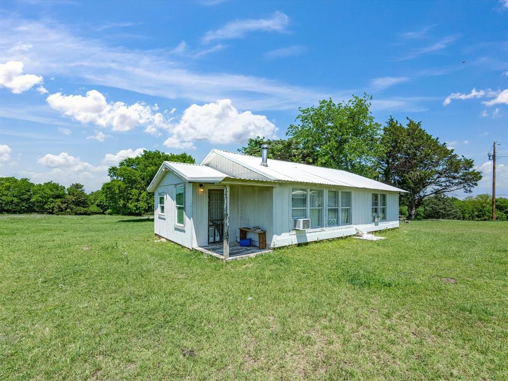 5444 Well Service Road Bowie, TX 76230 - Photo 24 of 38 a view of a house with a yard deck and a tree